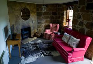 Buckland斯特奥瑞克皮尔斯别墅的客厅设有红色沙发和石制壁炉