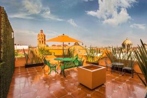 墨西哥城特姆普罗市长酒店的庭院配有桌椅和遮阳伞。