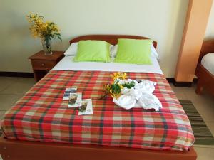 阿约拉港Hostal Casa Cascada的床上有毛巾和鲜花