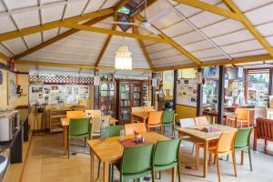 班加罗尔卡萨小屋酒店的餐厅设有木桌和绿色椅子