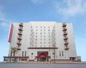 熊本熊本内斯特酒店的白色的建筑,旁边设有阳台