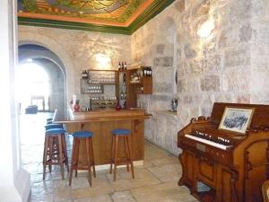 伯利恒Abrahams Herberge - Beit Ibrahem的一间带钢琴的厨房和一间带凳子的酒吧