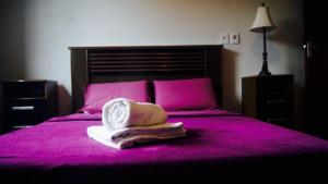 卡塔斯阿塔斯Rez Home Catas Altas的粉红色的床,上面有帽子和毛巾