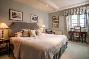 布罗德韦巴克兰庄园 - 瑞莱斯城堡酒店的一间卧室配有一张大床和一张书桌