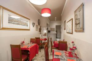 佛罗伦萨马萨乔酒店的一间用餐室,配有红色布艺桌椅
