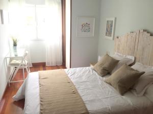 希洪Apartamento Playa Poniente的卧室配有一张带白色床单和枕头的大床。