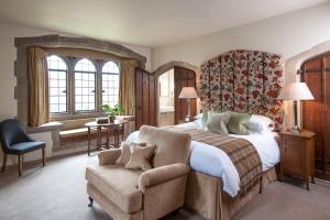 安伯利安柏丽城堡瑞莱斯酒店的一间卧室配有一张大床和一把椅子