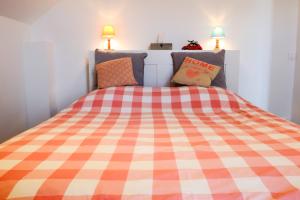 尚普索地区圣博内Appart'hôtel "Le Garage"的一间卧室配有一张带 ⁇ 子毯子的床