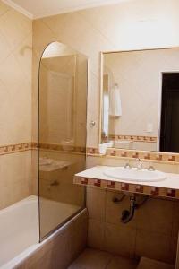 卢汉Hotel del Virrey的一间带水槽、浴缸和镜子的浴室