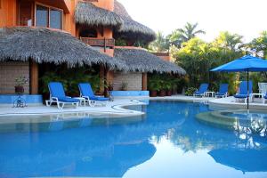 锡瓦塔塔内霍Villa Carolina Boutique Hotel ADULTS ONLY的一个带椅子和遮阳伞的游泳池的度假酒店