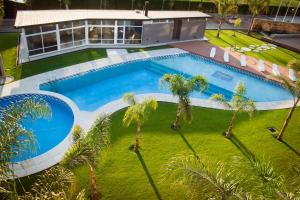 LeonesHotel Posada Maestosso的棕榈树庭院内游泳池的顶部景色
