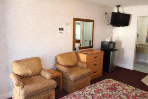 加洛韦大西洋城高地酒店的酒店客房配有一张床、两把椅子和一台电视