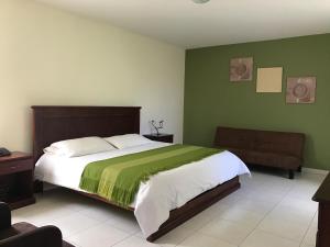 伊瓦拉La Quinta San Andrés的一间卧室设有一张带绿色墙壁的大床