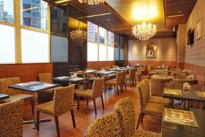 香港华丽铜锣湾酒店的用餐室配有桌椅和吊灯。