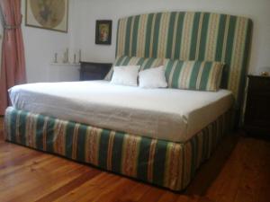 Palazzago蒙特韦约卡希纳生态住宿加早餐旅馆的一张带条纹床头板的床,上面有两个枕头