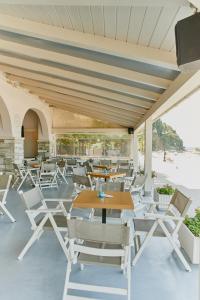 阿吉奥斯伊欧尼斯Kelly Hotel Agios Ioannis Pelion的庭院里摆放着几把椅子和桌子