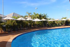 埃克斯茅斯埃克斯茅斯世外度假酒店的一个带椅子和遮阳伞的大型游泳池