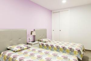 洛斯克里斯蒂亚诺斯Amazing sea view in Los Cristianos的卧室设有两张粉红色的床铺。