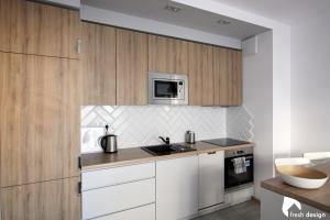 弗罗茨瓦夫Apartament nad Odrą的厨房配有白色橱柜和微波炉