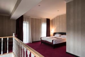 兹内特耶Kopala Tskneti Hotel的一间酒店客房,设有一张床和一个楼梯