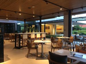 曼谷邦纳自豪公寓式酒店的餐厅设有桌椅和窗户。