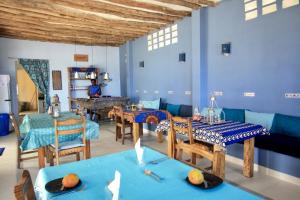 MsambweniSawa Sawa Beach House的一间拥有蓝色墙壁和木桌的用餐室