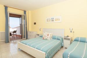 伊斯基亚艾波蕾佳娜酒店的一间卧室配有两张床和一张书桌