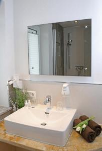 诺德林根Goldener Schlüssel mit Gästehaus Sina的浴室设有白色水槽和镜子
