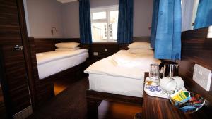 伦敦克莱斯特菲尔德酒店的小房间设有两张床和一张桌子