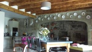 La Chaze-de-PeyreLa ferme de Félix的厨房设有石墙,配有桌椅