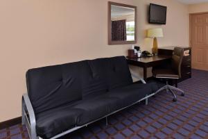 阿德莫尔阿德莫尔经济旅馆的一张沙发,房间配有一张桌子和一台电脑