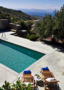 伊利达Kea Village Suites & Villas的一个带2把躺椅的游泳池和海洋
