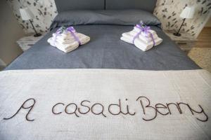 罗马卡萨迪本尼旅馆的一张有门牌和鞋的床