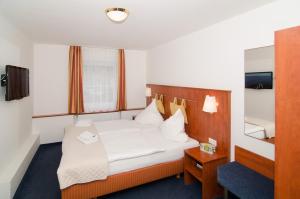 比肯费尔德Hotel -Restaurant Taormina的酒店客房,配有床和镜子