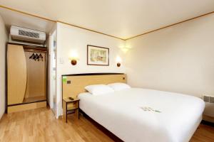 阿朗松钟楼阿伦松酒店的卧室配有一张白色大床