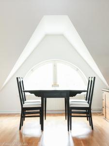 Vreta KlosterSödra Lund B&B的餐桌、两把椅子和窗户