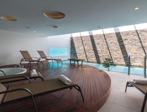 科洛尼亚-德尔萨克拉门托Dazzler by Wyndham Colonia的大楼内带椅子和游泳池的房间