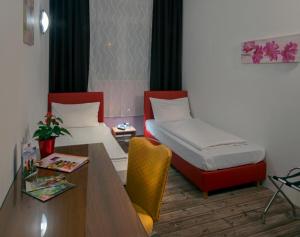 施托克劳凯瑟拉斯特酒店的客房设有书桌、床和桌子。