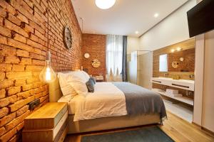 萨格勒布Indigo Centar的一间卧室设有砖墙、一张床和一个水槽
