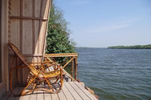 贡布竹制简易别墅度假村的两把椅子坐在水边的码头上