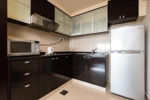 梳邦再也金字塔新城度假村套房公寓的厨房配有黑色橱柜和白色冰箱。