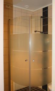 Gjerstad布鲁克蓝施故乡旅馆的浴室里设有玻璃门淋浴