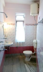 噶伦堡Deki Lodge的一间带卫生间、水槽和窗户的浴室