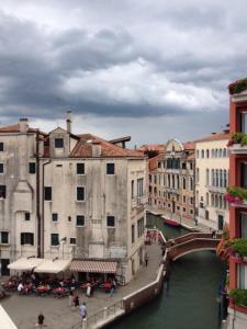 威尼斯卡黛珀罗酒店的一座建有建筑物的城市里河流上的桥梁