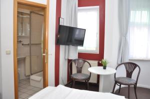 迈宁根安德尔卡佩勒酒店的客房设有1张床、1张桌子和1台电视。
