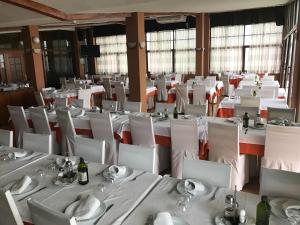 梅利利亚安佛拉酒店的用餐室配有白色的桌子和白色的椅子