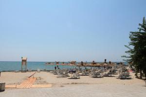 卡瓦尔纳阿莱格拉别墅酒店的海滩上设有椅子和遮阳伞,还有大海