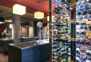 里昂里昂中央美居酒店 - 火车东站店 的餐厅里的酒吧,有一瓶葡萄酒