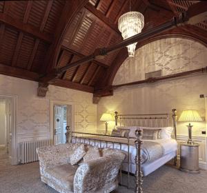 皮特洛赫里福纳城堡酒店的一间卧室配有一张床、一张沙发和一个吊灯。