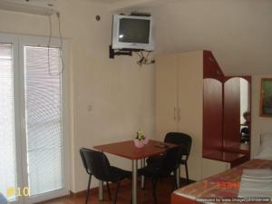 诺弗多伊兰丹达尔公寓的一间设有桌椅和墙上电视的房间